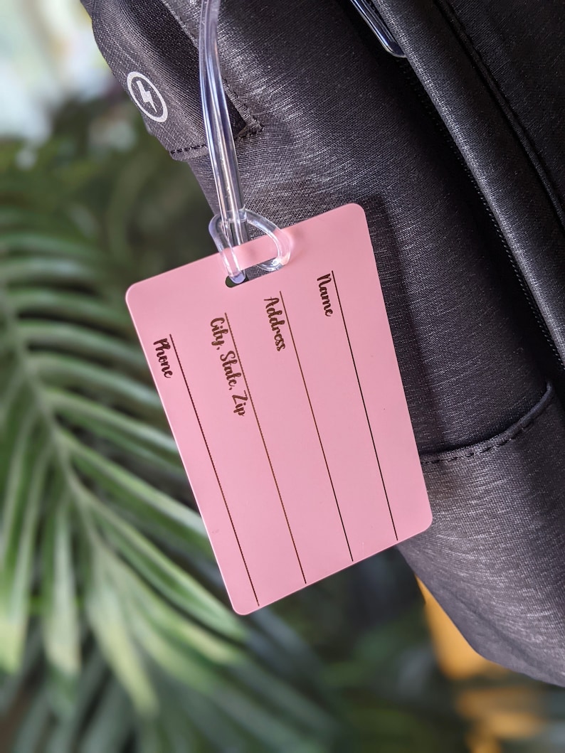 May include: Pink luggage tag with the words "Name", "Address", "City, State, Zip", and "Phone" printed on it.