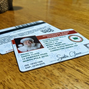 May include: A white and red International Sleigh Driver's License with a photo of Santa Claus. The license number is C1225-0012-25. The license was issued to Santa Claus at 12 Reindeer Road, North Pole 99705. The issue date is 12/25/1920 and the expiration date is 12/25/2525.