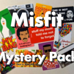 May include: A collection of colorful cards with various designs and text, including "Misfit Mystery Pack", "My Bag", "This is not your bag", "stuff my mom told me not to forget", and "Goodbye Ever Ever".