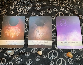 May include: Three tarot cards with celestial imagery. The first card shows a ram with the text "It's time to take action New Moon in Aries". The second card shows a sea goat with the text "Your hard work is paying off New Moon in Capricorn". The third card shows the symbol for the North Node with the text "Step out of your comfort zone North Node".