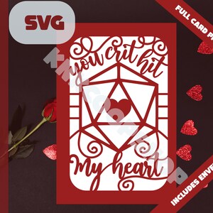 May include: A red card with a white die and the text "You crit hit my heart" in a white, decorative font. The card is designed for cutting and is part of a full card project.