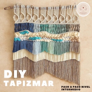 Puede incluir: Un tapiz de pared de macramé hecho a mano con una barra de madera. La obra de arte textil presenta capas de texturas tejidas en tonos crema, azul, verde azulado y marrón. Las palabras "DIY TAPIZMAR" se muestran en letras blancas.