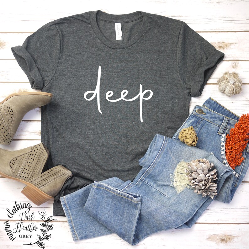 May include: A dark heather grey t-shirt with the word "deep" written in white cursive script.