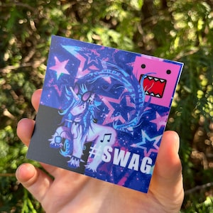 May include: A square sticker featuring a unicorn with sunglasses, musical notes, and the word "SWAG". The background is a mix of blue, purple, and pink with star shapes and a cartoon character.