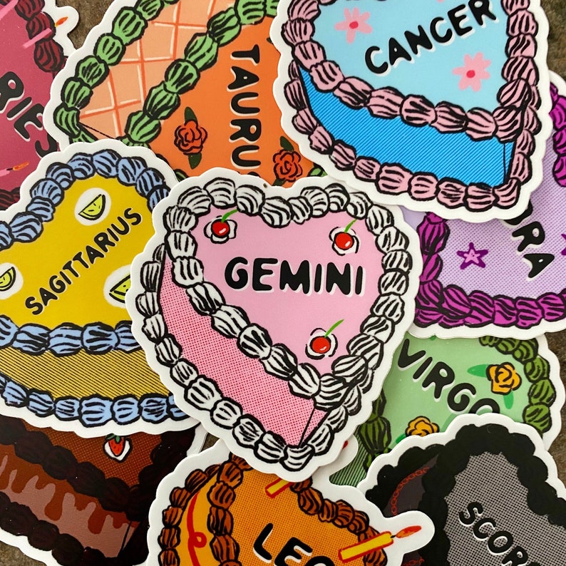 May include: A collection of twelve colorful stickers featuring the astrological signs. Each sticker is shaped like a heart and features a different zodiac sign with its name written in white text. The stickers are perfect for adding a touch of personality to laptops, water bottles, journals, and more.