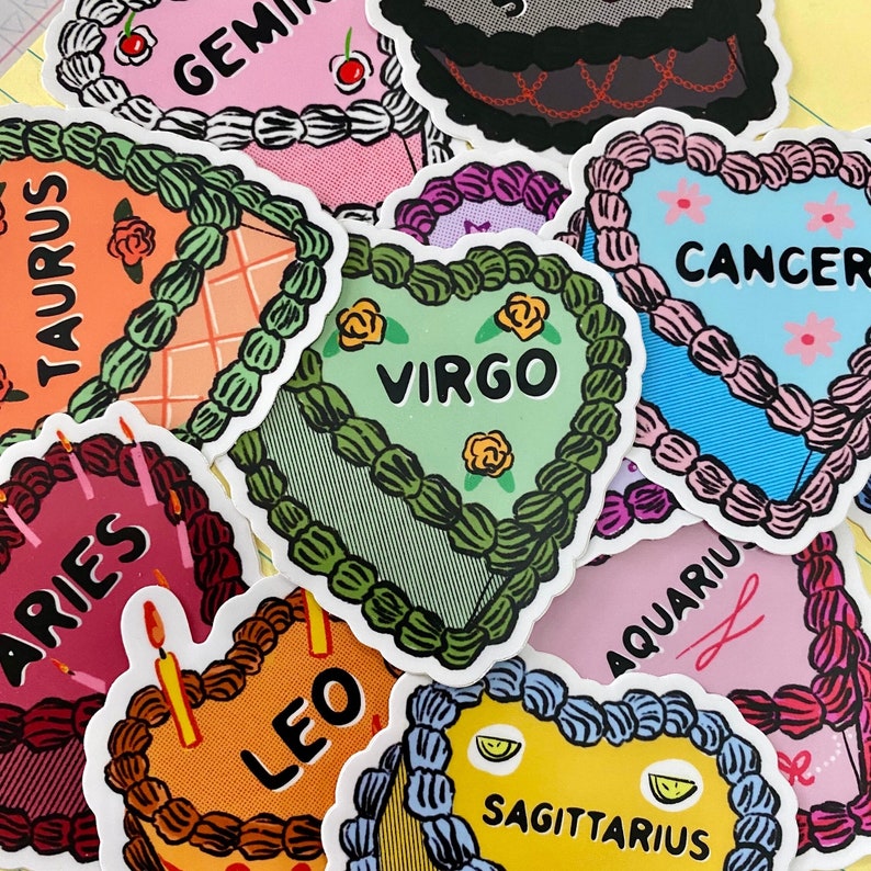 May include: A set of 10 colorful heart-shaped stickers featuring the astrological signs: Gemini, Taurus, Aries, Virgo, Cancer, Aquarius, Leo, Sagittarius, Capricorn, and Pisces. Each sticker has a unique design with a cake theme.