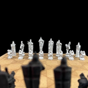 May include: A set of silver chess pieces on a wooden board. The pieces are in the shape of knights, bishops, rooks, queens, and kings. The pieces are arranged in a traditional chess formation.