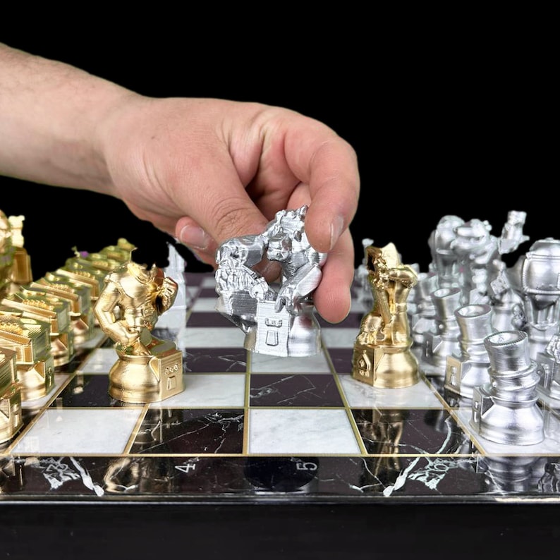May include: A silver chess piece in the shape of a creature is being moved on a black and white marble chessboard. The chessboard has gold trim and the other pieces are gold and silver.