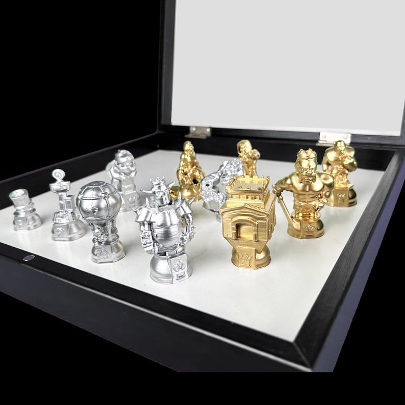 May include: A set of 10 silver and gold chess pieces in a black wooden box. The pieces are arranged in a display case with a white background. The pieces are all different shapes and sizes, and they are all very detailed.