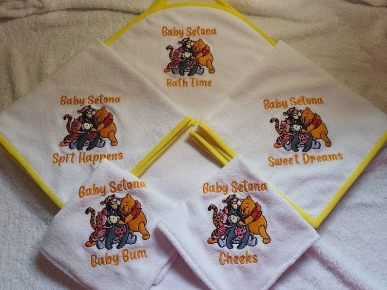 Pu&ograve; includere: Set di cinque asciugamani bianchi con bordino giallo, con personaggi di Winnie the Pooh e i suoi amici ricamati. Ogni asciugamano ha una frase diversa: "Bath Time", "Spit Happens", "Sweet Dreams", "Baby Bum" e "Cheeks".