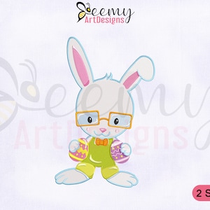 Puede incluir: Un conejo blanco con gafas y una pajarita verde sostiene dos huevos de Pascua coloridos. El conejo está de pie sobre un fondo blanco con el texto "Beemy ArtDesigns" y "2 SIZES" en las esquinas.