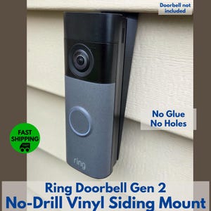 May include: A black and gray Ring Doorbell Gen 2 mounted on a vinyl siding. The doorbell has a camera lens and a circular button. The mount is designed for no glue and no holes installation.
