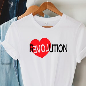 May include: White t-shirt with a red heart and the word "REVOLUTION" printed in black.