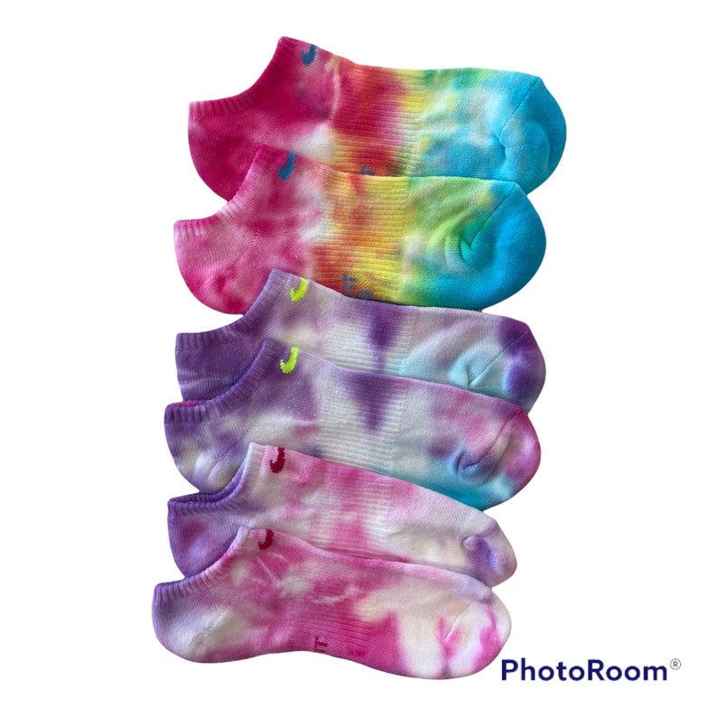 May include: A set of five colourful tie-dye no-show socks. The socks are in shades of pink, purple, blue, yellow and green.