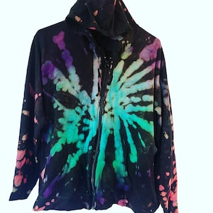 Może przedstawiać: Czarna bluza z kapturem i zamkiem błyskawicznym z wzorem tie-dye w odcieniach zieleni, fioletu i różu.
