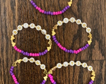 Pink, purple and gold beaded friendship bracelets with gold plated hearts and hardware, personalized with white and gold letter beads