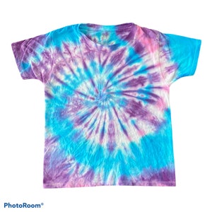 May include: A tie-dye t-shirt in shades of blue, purple, and white. The shirt has a spiral pattern.