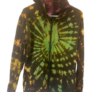 K&ouml;nnte beinhalten: Ein schwarzer Kapuzenpullover mit einem gr&uuml;n-gelb-violetten Batik-Muster.