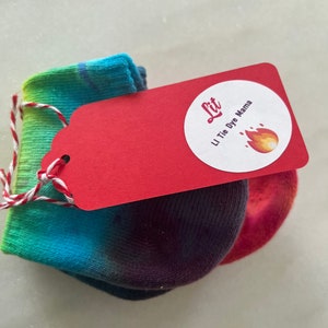 May include: A pair of tie-dye socks with a red tag that says "Lit" and "Li Tie Dye Mama" with a flame icon.