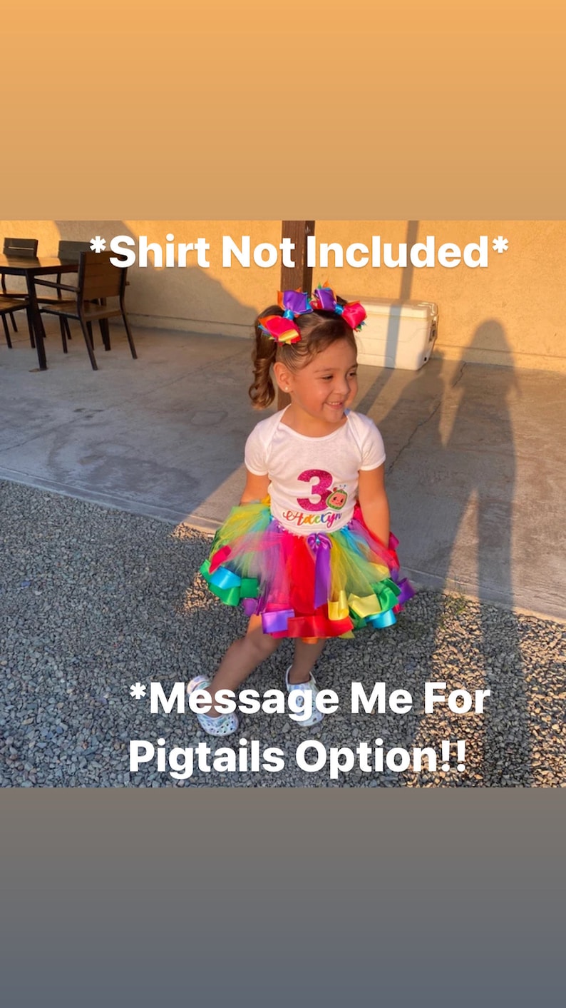 May include: A young girl wearing a white shirt with a pink and purple number 3 and the word "Happy" on it. She is wearing a rainbow tulle tutu with colorful ribbons. The girl has her hair in two pigtails with colorful bows. The text "*Shirt Not Included*" and "*Message Me For Pigtails Option!" is visible in the image.