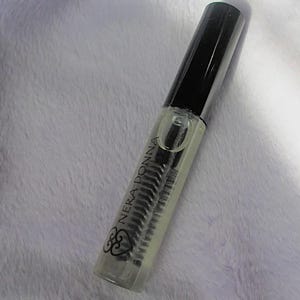 May include: A clear glass bottle with a black cap and a black brush applicator. The bottle is labeled "Nera Donna" with a heart symbol.