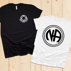May include: Two t-shirts, one black and one white, with different designs. The black t-shirt has a white square with a circle inside and the text "Just for Today". The white t-shirt has a black circle with the letters "NA" inside.