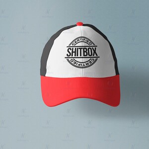May include: A black and white baseball cap with a red brim. The front of the cap has a white circle with the text "CERTIFIED SHITBOX CERTIFIED" in black.