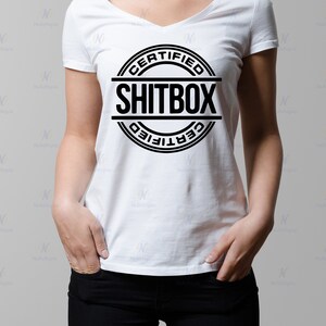May include: A white t-shirt with a black circle graphic that says "CERTIFIED SHITBOX" in all caps.