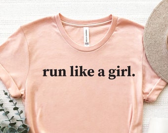 May include: A peach-colored t-shirt with the text "run like a girl." printed in black.