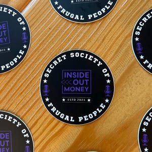 May include: Four black and white round stickers with the text "Secret Society of Frugal People" and a purple logo that says "Inside Out Money" with a star on either side of the text "Estd 2023".
