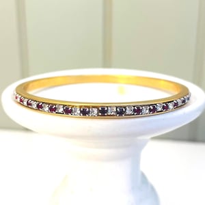 Vintage eternity gold tone bangle bracelet. Faux ruby and rhinestones. Beautiful! Excellent condition. July birthstone