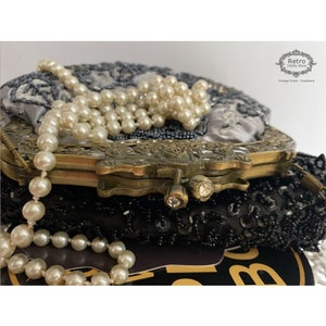 Pu&ograve; includere: Una borsa da sera vintage in perle con fodera in raso argentato e chiusura in ottone. La borsa &egrave; decorata con perle e paillettes. La borsa &egrave; chiusa e la chiusura &egrave; chiusa.