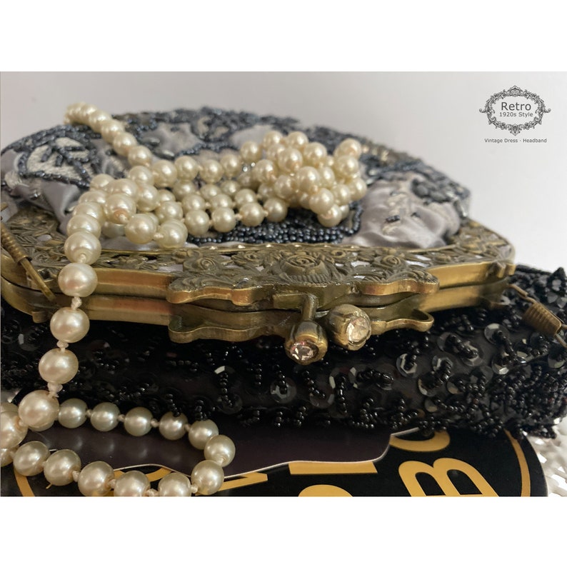 Pu&ograve; includere: Una borsa da sera vintage in perle con fodera in raso argentato e chiusura in ottone. La borsa &egrave; decorata con perle e paillettes. La borsa &egrave; chiusa e la chiusura &egrave; chiusa.