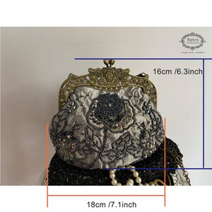 Pu&ograve; includere: Una pochette in satin argento con cornice in metallo dorato e ricamo floreale perlato. La pochette misura 16 cm di altezza e 18 cm di larghezza.