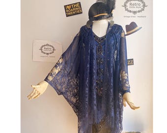 May include: A navy blue lace shawl with fringe trim. The shawl has a delicate floral pattern and is perfect for a vintage-inspired look.