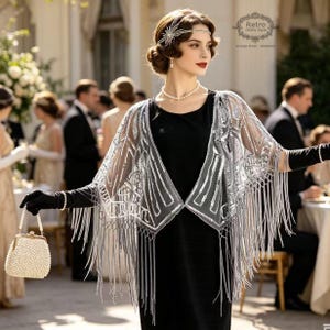 May include: A woman in a black dress and a silver beaded shawl with fringe. She wears a pearl necklace, earrings, and a headband. She holds a pearl-covered purse and black gloves. The image has a vintage style.