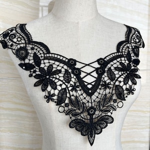 Może przedstawiać: Czarna koronka ozdobna z delikatnym wzorem kwiatowym i krzyżowym wzorem w środku. Ta koronka idealnie nadaje się do dodania elegancji każdemu projektowi.