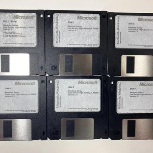 May include: A set of six black 3.5-inch floppy disks for Microsoft Windows 3.1. Each disk features a white label with the Microsoft logo, disk number, and technical specifications including high-density 1.44MB format and copyright dates.