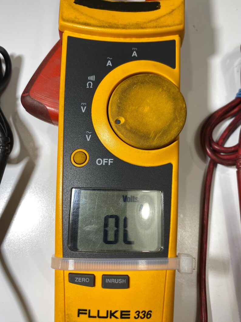 Pu&ograve; includere: Un multimetro a pinza Fluke 336 giallo e nero dotato di una manopola centrale per selezionare le modalit&agrave; di misurazione elettrica, uno schermo LCD digitale che mostra OL e pulsanti etichettati ZERO e INRUSH, con puntali rosso e nero.