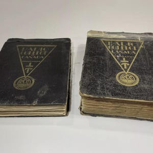 May include: Two vintage black hardcover books with gold lettering. The books are titled "Radio College Canada" and feature a gold emblem with a cross and the letters "RCC".