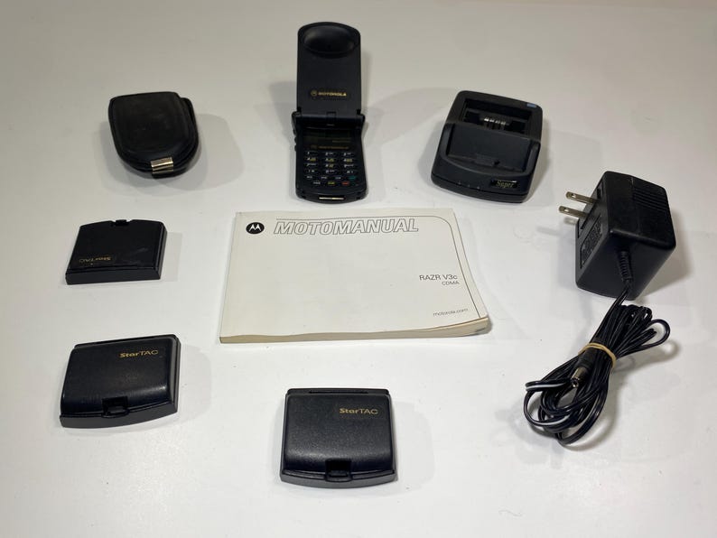 Lote de teléfono plegable Motorola StarTAC con base de carga, baterías, manual y estuche. Sin probar. Para repuestos. imagen 5