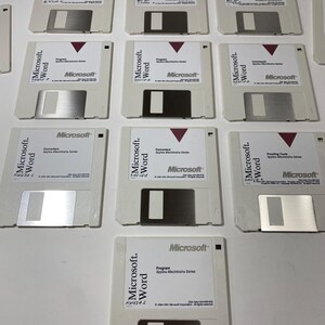 Könnte beinhalten: Acht 3,5-Zoll-Disketten mit der Aufschrift "Microsoft Word" und verschiedenen Versionen des Programms. Die Disketten sind weiß mit einem roten Microsoft-Logo und Text.
