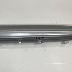 May include: A silver and gray model of a Zeppelin airship. The model has detailed features, including the D-LZ 127 markings and gondolas. The airship is a classic design, with a streamlined shape and multiple fins.
