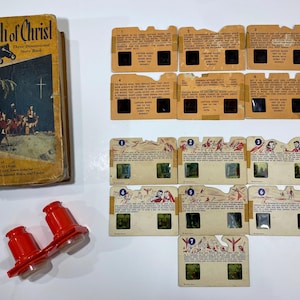 May include: Vintage "The Birth of Christ" Three Dimensional Story Book with accompanying slides and a red viewer. The book cover features an illustration of the nativity scene. The slides depict scenes from the story, and the viewer allows for 3D viewing.