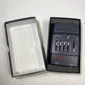 May include: A dark gray Fishman Prefix Pro Blend acoustic guitar preamp system with a rectangular control panel featuring sliders for bass, middle, treble, brilliance, and volume, a phase switch, a low battery indicator, and output and input ports.