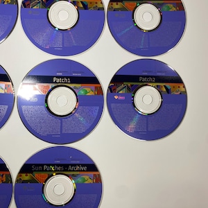 May include: Six CDs with purple and blue labels. The labels have the text "Sun Microsystems" and "Patch 1" or "Patch 2". One CD has the text "Sun Patches - Archive".