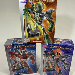 May include: Three Mega Bloks Gyro Racers boxes. The top box features a green and grey robot labelled "Burnout." The other boxes show red "Slingshot" and orange "Downforce" robots. Each box has a robot illustration.