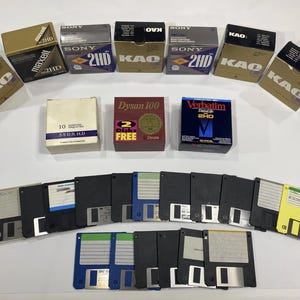 May include: A collection of old 3.5-inch floppy disks and their boxes. Brands include Sony, KAO, and Maxell. The disks are black with different coloured labels, and the packaging has text such as "2HD" and "Dysan 100".
