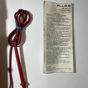 Pu&ograve; includere: Un puntale elettrico rosso con un elastico blu e una scheda di istruzioni bianca per la pinza amperometrica Fluke 336 e 337. La scheda presenta avvertenze multilingue, il logo Fluke, il numero di parte 1549876 e la data del 2001.