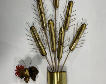 May include: A vintage metal wall sculpture featuring a stylized arrangement of golden cattails with thin, spiky accents. A separate metal butterfly with a red flower is also included. The sculpture is likely from the mid-century era.
